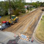 Large road reclaimer attachment performing full depth reclamation for road reconstruction project.